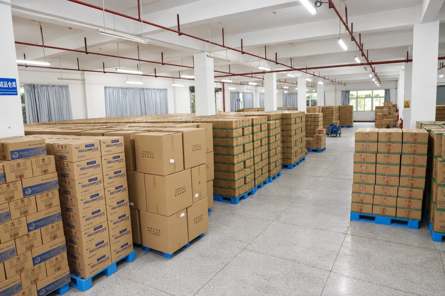 Productos terminados en cajas sobre tarimas azules en el almacén de Airsun.