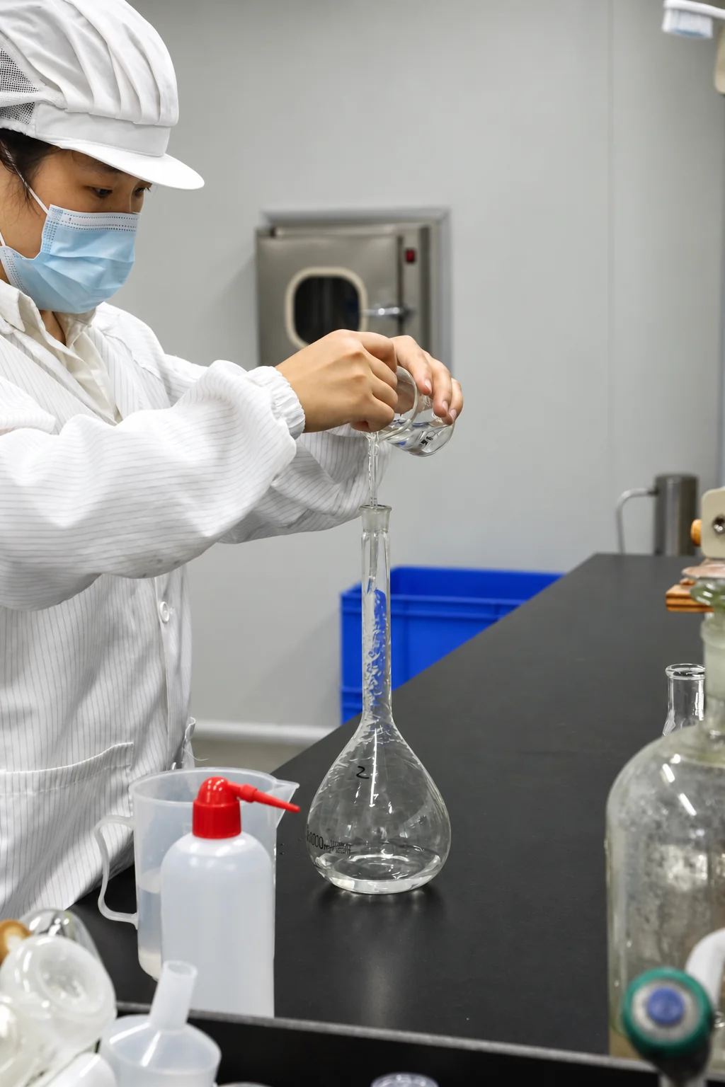 Un técnico de laboratorio de Airsun vierte líquido en un matraz aforado.