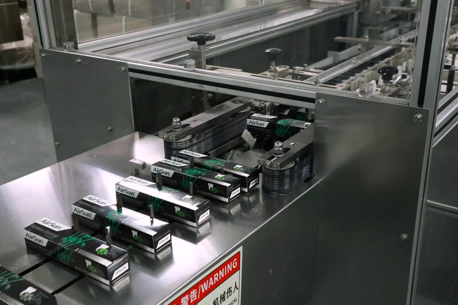 Cajas de pasta dental de Airsun avanzando por los equipos de empaque de la línea.